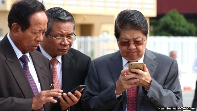 Các quan chức cấp cao Campuchia, bao gồm Phó Thủ tướng kiêm Bộ trưởng Quốc phòng Tea Banh (trái) đang &quot;lướt&quot; Facebook trên điện thoại thông minh. Ảnh: Hean Socheata/VOA Khmer.