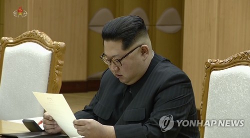 Chủ tịch Cộng hòa dân chủ nhân dân Triều Tiên Kim Jong-un đọc thư của Tổng thống Hàn Quốc Moon Jae-in ngày 6/3. Ảnh: Yonhap.