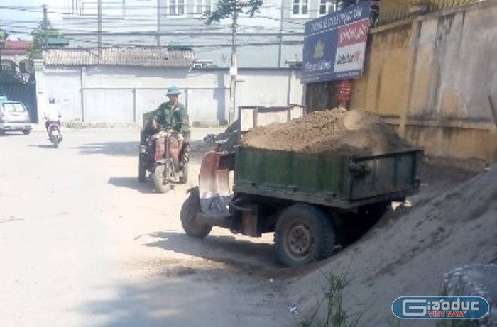 Vật liệu xây dựng lấn chiếm lòng, lề đường vẫn ngang nhiên tồn tại (Ảnh Chí Nhân)