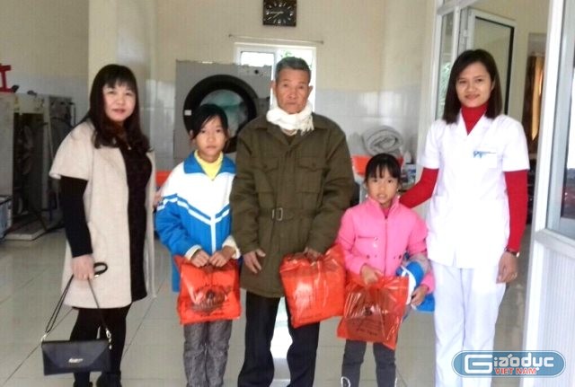 Cô Xoan (bên trái) trao quà từ thiện cho hai em học sinh mồ côi cha mẹ. Ảnh: Nhân vật cung cấp.