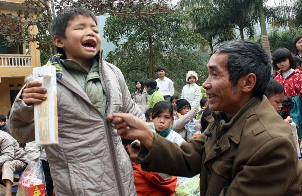 Nụ cười rạng ngời của hai bố con em Bàn Văn Quý (6 tuổi, học sinh lớp 1A trường tiểu học Vinh Tiền – Tân Sơn - Phú Thọ, em bị đau mắt đỏ một thời gian, khi gia đình đưa em ra bệnh viện Nhi Trung ương thì hai mắt em đã không thể cứu được. Em phải cắt bỏ mắt phải của mình). Ảnh: Giàng A Cối