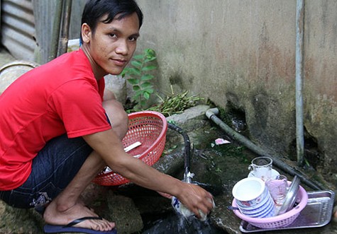 Sau khi ru cháu ngủ, Toàn tranh thủ rửa chén bát để chuẩn bị cơm tối cho gia đình