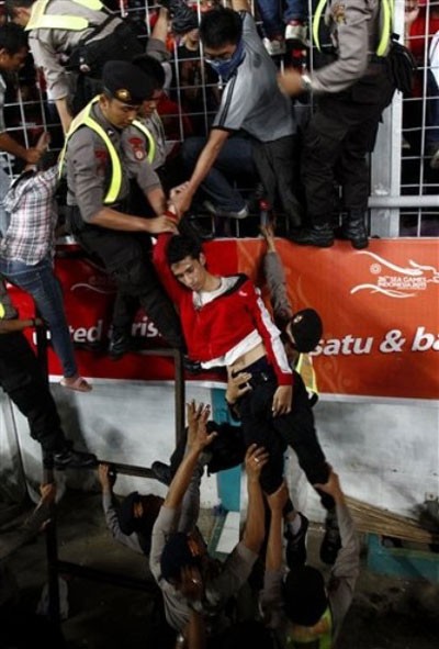 Cảnh sát Indonesia đưa một CĐV bất tỉnh xuống sau cảnh hỗn loạn