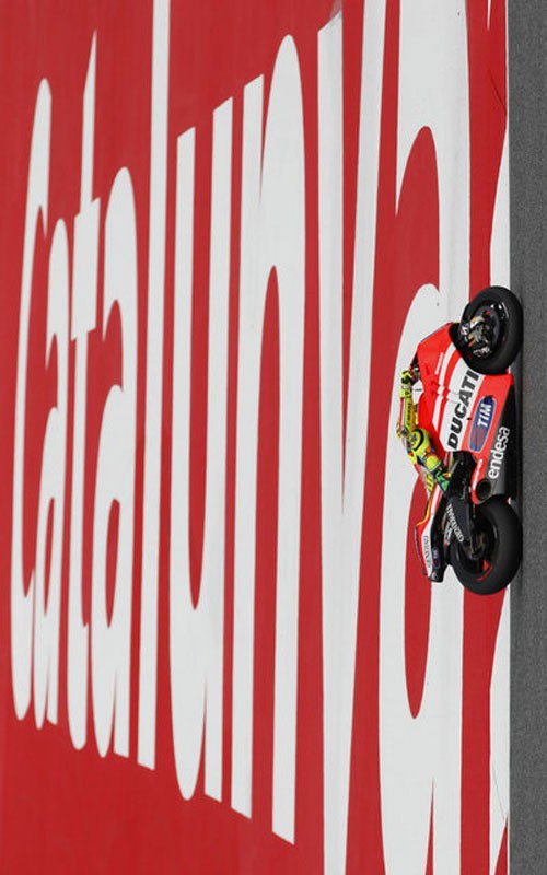 Valentino Rossi đi qua một tấm biển lớn đề Catalunya