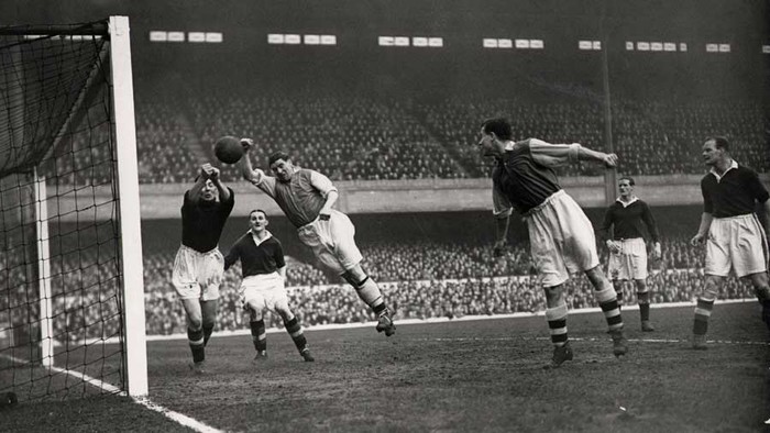 18/2/1939: Thủ môn Vic Woodley của Chelsea từ chối pha dứt điểm kiểu “Bàn tay của Chúa” của Ted Drake (Arsenal) tại Highbury.