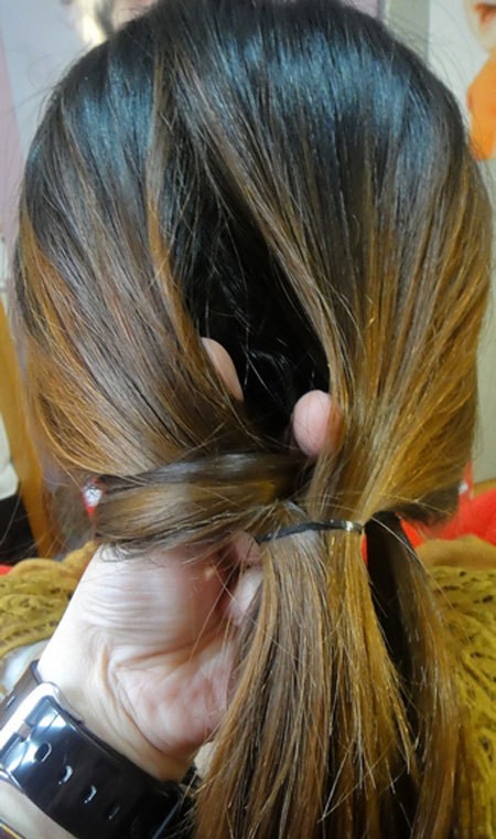 Tách giữa phần tóc buộc ra, luồn hai phần tóc ở hai bên vào trong đó. Xem thêm: Những kiểu tóc ấn tượng cho bạn gái hè 2012.