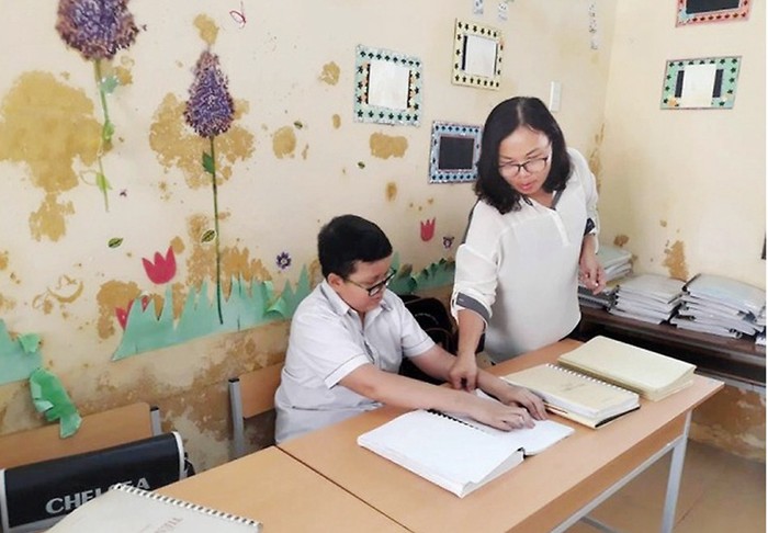 Cô giáo Nguyễn Thị Thảo hướng dẫn học sinh khiếm thị học bài (Ảnh: Lê Trung Cường)