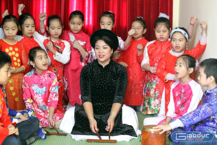 Nữ hiệu trưởng Nguyễn Thị Thắm cùng học sinh Trường Tiểu học Nguyễn Công Trứ biểu diễn một tiết mục hát ca trù (Ảnh: Lã Tiến)