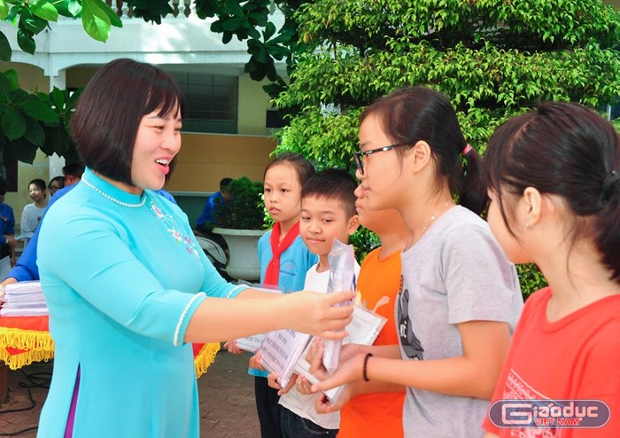 Lãnh đạo nhà trường trao qua tặng các em học sinh có hoàn cảnh khó khăn vươn lên trong học tập (Ảnh: Quyết Cương)