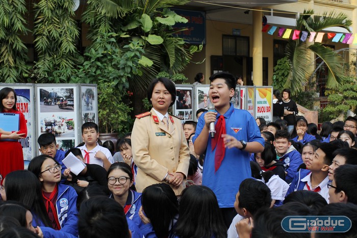 Các em học sinh thể hiện sự hiểu biết của mình về việc thực hiện Luật giao thông đường bộ (Ảnh: Lã Tiến)