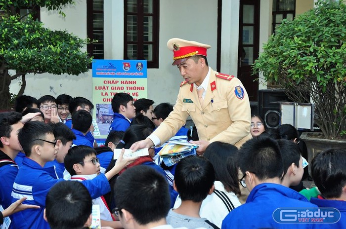 Cán bộ Phòng Cảnh sát giao thông đường bộ, đường sắt (Công an Hải Phòng) phát tài liệu về an toàn giao thông tới học sinh (Ảnh: Lã Tiến)