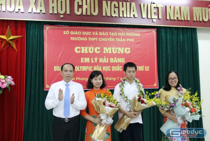 Phó giáo sư, Tiến sĩ Lê Quốc Tiến, Giám đốc Sở Giáo dục và Đào tạo Hải Phòng tặng hoa chúc mừng em Lý Hải Đăng cùng cô giáo chủ nhiệm Nguyễn Thị Thanh Thúy (Ảnh: Lã Tiến)