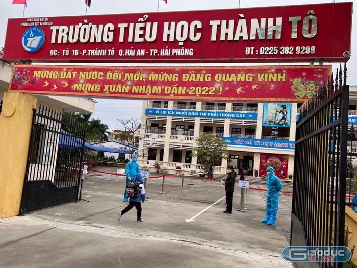 Trường Tiểu học Thành Tô bố trí nhân viên, giáo viên mặc đồ bảo hộ đón học sinh tại cổng trường (Ảnh: PL)