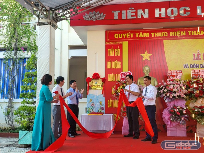 Các đại biểu thực hiện nghi thức gắn biển Trường Tiểu học Hải Thành đạt chuẩn Quốc gia mức độ 2 (Ảnh: Lã Tiến)