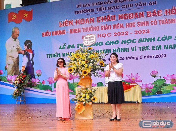 Đại diện cha mẹ học sinh lớp 5 tặng hoa tri ân cán bộ, giáo viên, nhân viên nhà trường (Ảnh: Vũ Dũng)