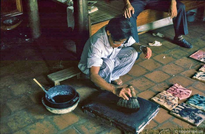 Nghệ nhân Nguyễn Đăng Chế đang dùng chổi lá thông để tạo nên những bức tranh Đông Hồ đầy màu sắc.