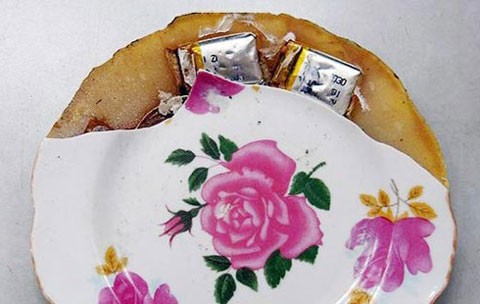 Hai gói bột &quot;lạ&quot; màu trắng trong đĩa sứ Trung Quốc (ảnh Vietnamnet)