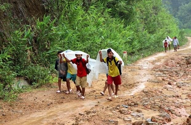 Học sinh vùng cao đội mưa đến trường. (Ảnh: Việt Hoàng/TTXVN)