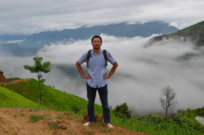 Nhà báo Dương Đình Tường đi bộ lên núi ở tỉnh Sơn La sau buổi trời mưa. Anh phải mượn dép lê để đi vì bùn đất nhiều. (Ảnh: NVCC)