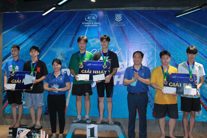 Nguyễn Hoàng Minh Giang (áo đen bên phải) giành giải Nhất bơi ếch nam với thời gian 31 giây 07, và kế bên là Nguyễn Hoàng Tinh Tú (10Q1) giành giải Nhất bơi tự do nam với thời gian 22 giây 97. (Ảnh: Mạnh Đoàn)