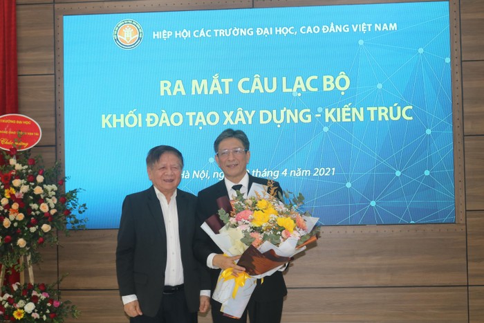 Phó Giáo sư. Tiến sĩ Trần Xuân Nhĩ - nguyên Thứ trưởng Bộ Giáo dục và Đào tạo, Phó chủ tịch Thường trưc Hiệp hội Các trường đại học, cao đẳng Việt Nam tặng hoa cho Phó Giáo sư Phạm Duy Hòa - Chủ nhiệm Câu lạc bộ (Ảnh: Nhà xuất bản Xây dựng)