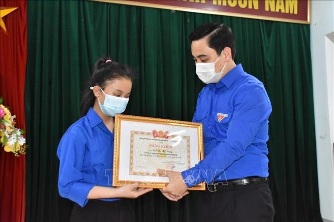 Bí thư Tỉnh đoàn Hà Tĩnh tặng bằng khen cho em Bùi Thị Mỹ Dung vì hành động đẹp trả lại tiền cho người đánh mất (Ảnh: TTXVN)