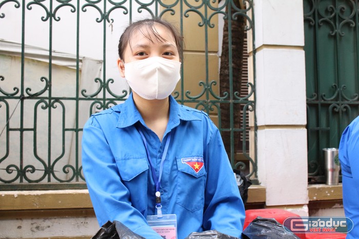 Trần Thu Trang, học sinh lớp 11, Trường Trung học phổ thông Yên Hòa tham gia tình nguyện, giúp các thí sinh thực hiện tốt công tác phòng dịch. (Ảnh: Phạm Minh)
