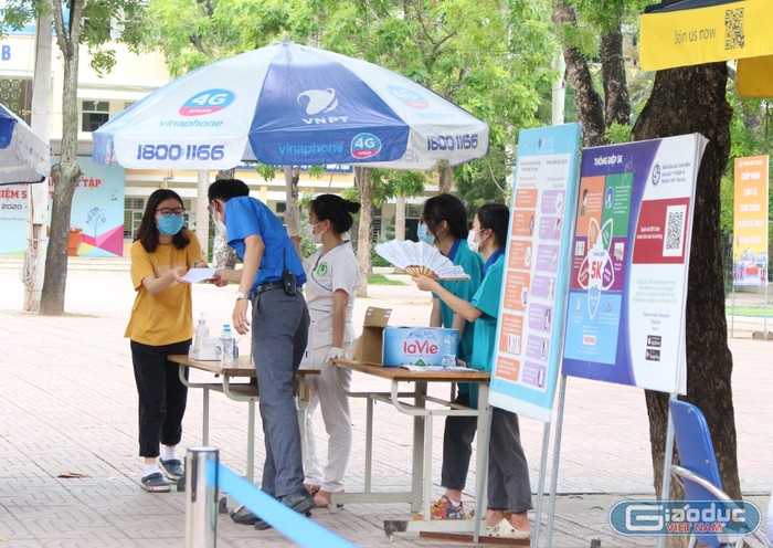 Anh Tạ Mạnh Nguyên Anh- Phó Chủ tịch Hội Liên hiệp thanh niên Việt Nam phường Yên Hòa (Cầu Giấy) giúp phụ huynh mang giấy tờ cho thí sinh bị quên. (Ảnh: Phạm Minh)