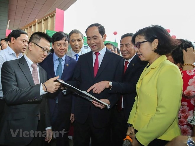 Chủ tịch nước Trần Đại Quang thăm gian trưng bày của TTXVN tại Hội báo toàn quốc. (Ảnh: Lê Minh Sơn/Vietnam+).