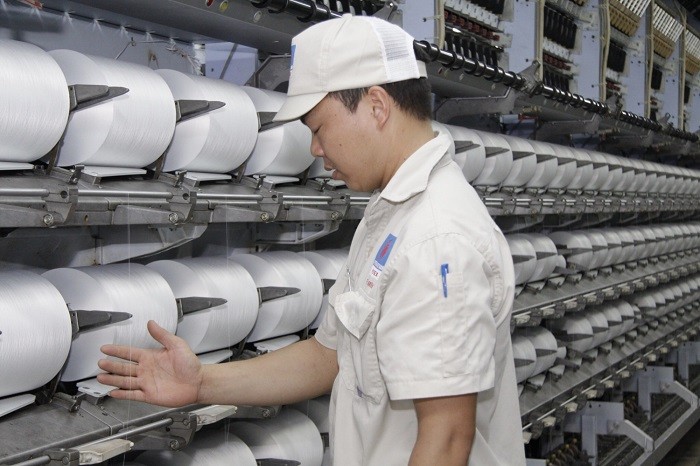 Công nhân vận hành phân xưởng sản xuất sợi DTY của Nhà máy Xơ sợi Đình Vũ đang kiểm tra chất lượng sản phẩm ngay trên dây chuyền sản xuất.