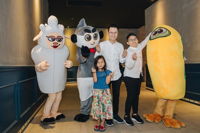 Các thành viên trong gia đình ca sĩ Hoàng Bách thích thú khi chụp hình cùng mascot dế thương của các nhân vật trong phim.