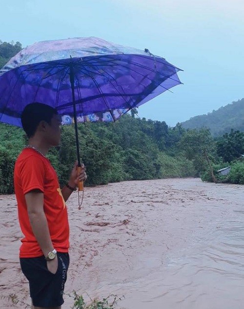 Thầy hiệu trưởng đứng lặng bên dòng suối cuộn chảy đục ngầu (Ảnh: tác giả cung cấp).