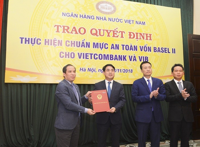 Đại diện Ban Lãnh đạo Ngân hàng nhà nước Việt Nam, ông Đoàn Thái Sơn – Phó Thống đốc (ngoài cùng bên trái) trao quyết định công nhận Vietcombank thực hiện chuẩn mực an toàn vốn Basel II (đại diện Ban Lãnh đạo Vietcombank nhận quyết định: Ông Nghiêm Xuân Thành – Chủ tịch Hội đồng quản trị (thứ 2 từ trái sang; ông Phạm Quang Dũng – Tổng Giám đốc, Trưởng Ban triển khai chương trình Basel II (thứ 2 từ phải sang) và ông Nguyễn Mạnh Hùng - Ủy viên Hội đồng quản trị, Phó Trưởng Ban thường trực Ban triển khai chương trình Basel II Vietcombank (ngoài cùng bên phải).