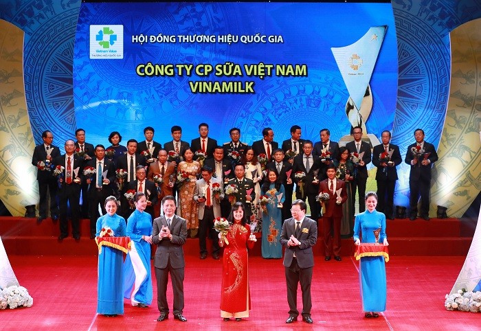 Bà Nguyễn Minh Tâm - Giám đốc Chi nhánh Vinamilk Hà Nội nhận hoa và biểu trưng Thương hiệu quốc gia từ Phó Thủ tướng Trịnh Đình Dũng và Bộ trưởng Bộ Công thương Trần Tuấn Anh.