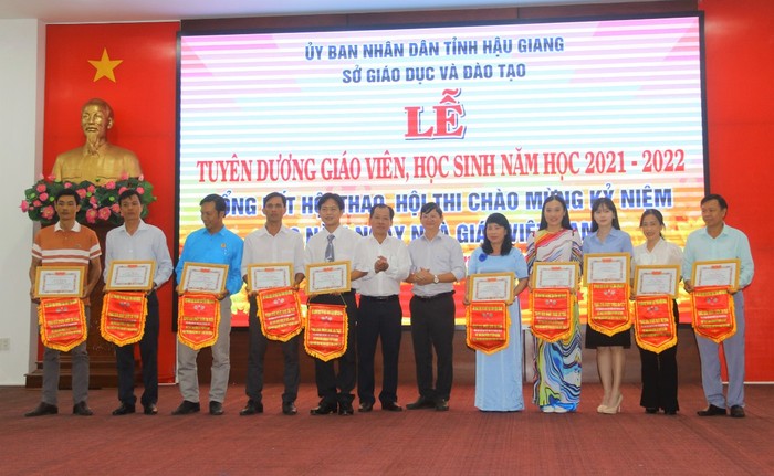 Lãnh đạo Sở Giáo dục và Đào tạo tỉnh Hậu Giang tặng bằng khen, cờ lưu niệm cho tập thể giáo viên. (Ảnh: Sở Giáo dục và Đào tạo tỉnh Hậu Giang).