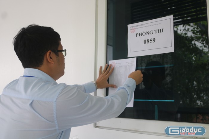 Thầy Nguyễn Đức Vượng - Thư kí Điểm thi Trường Trung học cơ sở và Trung học phổ thông Lương Thế Vinh đang dán danh sách thí sinh tại các phòng thi. (Ảnh: Doãn Nhàn)