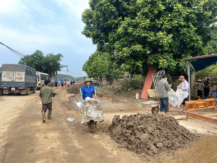 Sinh viên hỗ trợ khơi thông đường xá, cống rãnh giúp người dân. Ảnh: NTCC.