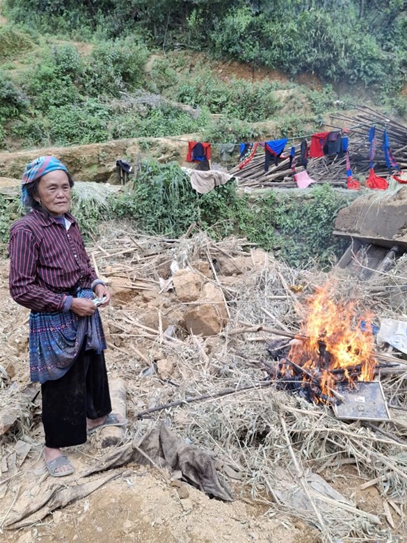 Bà nội của em Thào Thị Nhè nhặt nhạnh những kỷ vật còn sót lại của cha mẹ em để đốt đi theo phong tục địa phương. Ảnh: NTCC.