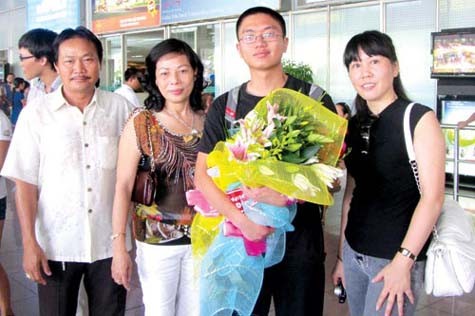 Lê Anh Dũng (ôm hoa) được người thân chúc mừng khi về Việt Nam