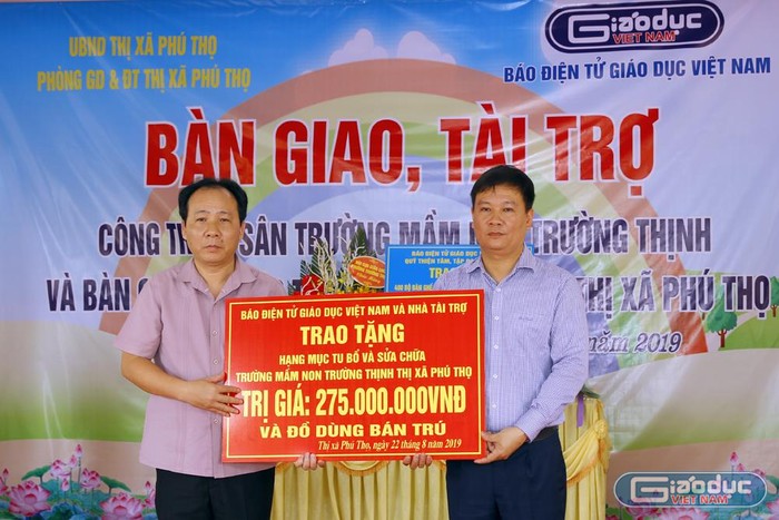 Ông Hà Tuấn Anh - Phó chủ tịch thị xã Phú Thọ (người bên trái) đại diện nhận quà tài trợ từ Báo điện tử Giáo dục Việt Nam do Nhà báo Nguyễn Tiến Bình trao tặng. Ảnh: Tùng Dương.