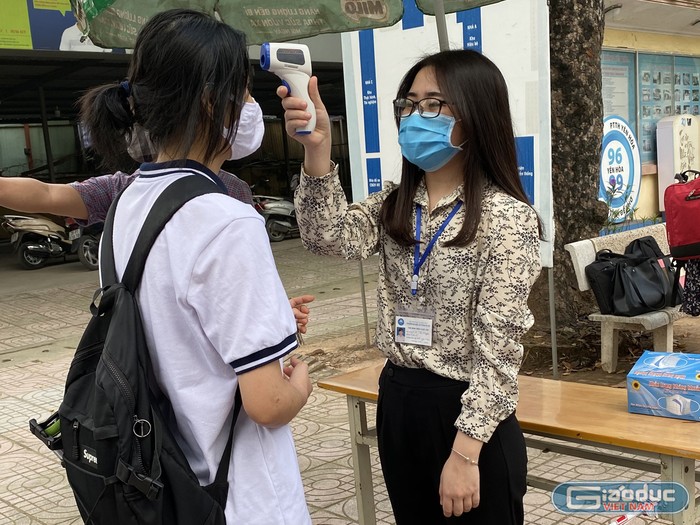 Học sinh Trường Trung học phổ thông Yên Hòa đều được đo thân nhiệt trước khi vào trường. Ảnh: Thanh Phương 11 d4.