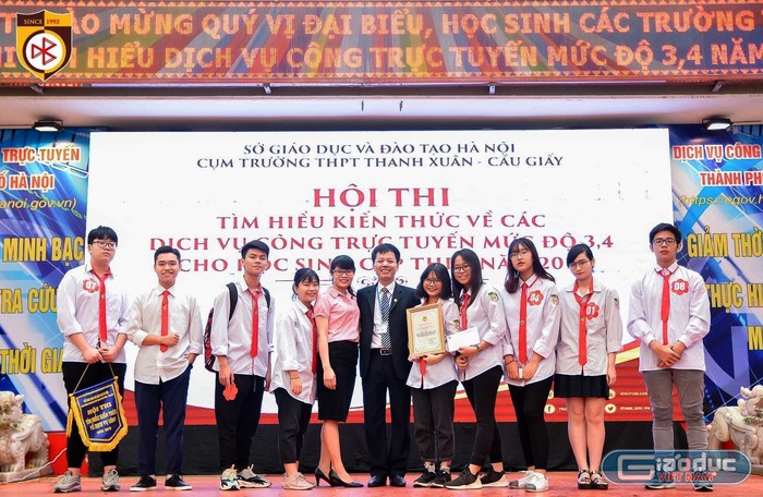 Thầy Đàm Tiến Nam - Hiệu trưởng Trường Trung học cơ sở, Trung học phổ thông Nguyễn Bỉnh Khiêm (người đứng giữa ảnh) và cô giáo Trang cùng các em học sinh của nhà trường. Ảnh: NVCC.