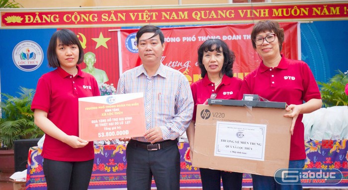 Nhà giáo Vũ Anh Tú - Phó hiệu trưởng Trường Trung học phổ thông Đoàn Thị Điểm (ngoài cùng bên trái ảnh), đại diện cho ban giám hiệu nhà trường trao quà tại xã Lộc Thủy, tỉnh Quảng bình. Ảnh: Hữu Thành.