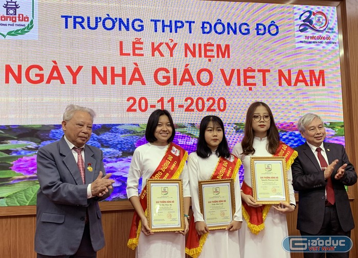 Tiến sĩ Võ Thế Quân (bên phải ảnh) - Hiệu trưởng Trường Trung học phổ thông Đông Đô trao Giải thưởng Đông Đô cho 3 em học sinh của nhà trường đạt thành tích cao trong họp tập. Ảnh: Tùng Dương.