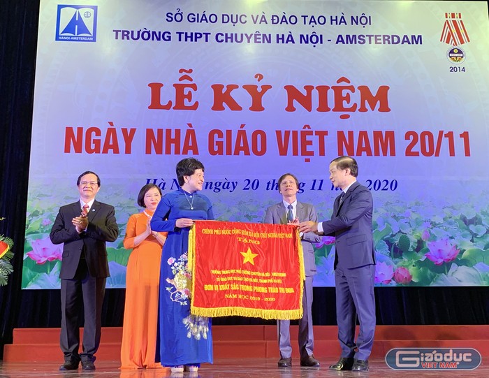 Ông Phạm Tất Thắng (ngoài cùng bên phải) - Phó Chủ nhiệm Ủy ban Văn hóa, Thanh niên, Thiếu niên và Nhi đồng của Quốc hội đang trao tặng Cờ thi đua của Chính phủ cho tập thể cán bộ giáo viên Trường trung học phổ thông Chuyên Hà Nội - Amsterdam tại lễ kỷ niệm. Ảnh: Tùng Dương.