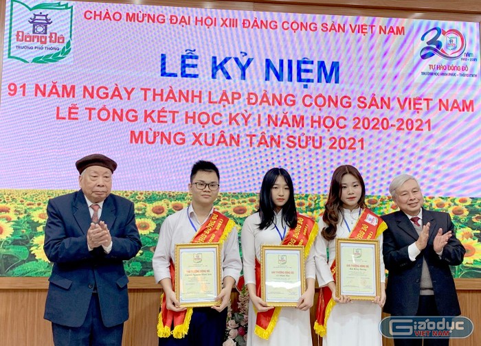 Tiến sĩ Võ Thế Quân - Bí thư chi bộ, hiệu trưởng nhà trường (phải ảnh) và Giáo sư, Nhà giáo nhân dân Phạm Quý Tư trao Giải thưởng Đông Đô cho ba học sinh của nhà trường đã có thành tích cao trong học tập. Ảnh: Tùng Dương.