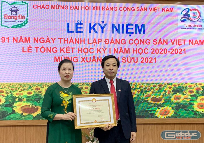 Nhà giáo Đàm Xuân Quang (bên phải) - Phó Chánh Văn phòng Sở Giáo dục và Đào tạo Hà Nội trao giấy khen cho Hội khuyến học Trường Trung học phổ thông Đông Đô. Ảnh: Tùng Dương.