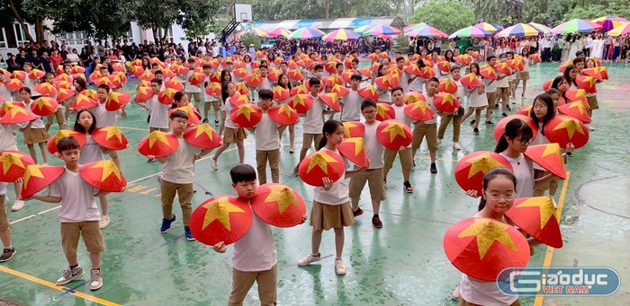 Hàng trăm học sinh Trường Trung học cơ sở - Trung học phổ thông Đoàn Thị Điểm với những chiếc nón và biểu tượng cờ tổ quốc trong tiết mục múa. Ảnh: Tùng Dương.