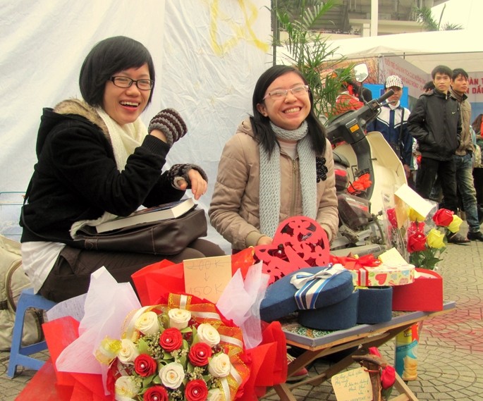Ngồi cạnh vị trí trung tâm của Lễ hội Xuân hồng 2012, Hồ Thị Quỳnh Trang - sinh viên năm 2, ĐH Ngoại thương và bạn học cùng bán hoa giấy.