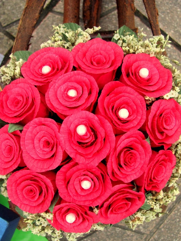 Những hạt cườm trắng được đính khéo léo thành hình chữ Y trên những bông hồng đỏ rực, tạo điểm nhấn cho giỏ hoa giấy.
